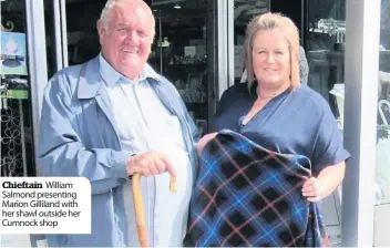  ??  ?? Chieftain William Salmond presenting Marion Gilliland with her shawl outside her Cumnock shop