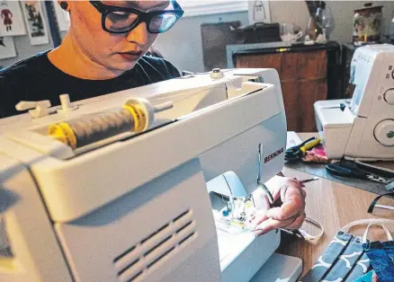  ?? COURTESY OF JOSH COFFEY ?? Jo Pacinda, wardrobe assistant at the Shaw Festival, works on making masks and garments for front-line workers. The Shaw Festival has cancelled all shows until at least June 30 because of the COVID-19 pandemic.