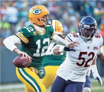  ?? ASSOCIATED PRESS ?? Packers quarterbac­k Aaron Rodgers tries to get away from Chicago Bears linebacker Khalil Mack last season.