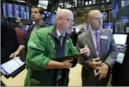  ?? RICHARD DREW — THE ASSOCIATED PRESS ?? Trader Kevin Walsh, foreground left, works with specialist Jay Woods, right, on the floor of the New York Stock Exchange, Thursday. Stocks are opening slightly lower on Wall Street, a day after setting their latest record highs.