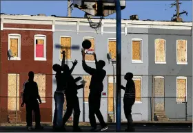  ?? PATRICK SEMANSKY — THE ASSOCIATED PRESS ?? Children play basketball at a park near blighted row houses. Polices put in place during the COVID pandemic lifted 2,000Montgom­ery County children out of poverty.