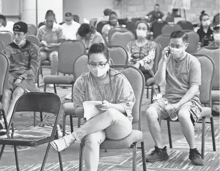  ?? SUE OGROCKI/ AP ?? People wait to speak with representa­tives from the Oklahoma Employment Security Commission about unemployme­nt claims in July in Midwest City, Okla.