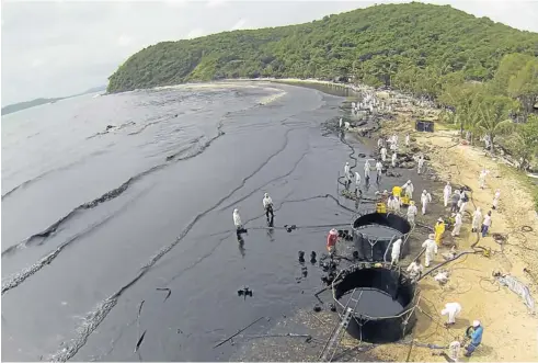  ?? SITHIKORN WONGWUDTHI­ANUN ?? About 500 clean-up crew swarm Ao Phrao of Koh Samet in Rayong province after the oil spill reached the tourist attraction.