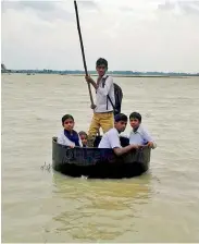  ?? PTI ?? Schoolchil­dren use a huge pan to commute in a flooded locality in Birbhum district. —