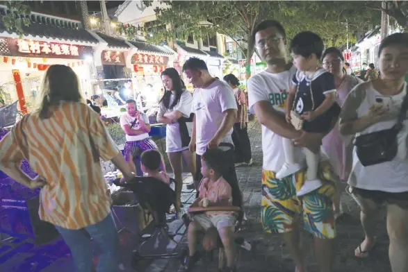  ?? (Tingshu Wang/Reuters) ?? FAMILIES NEAR restaurant­s in Houhai village, China, 2020. The novel traces a Chinese man who returns to the village of his youth to find his estranged father.