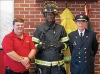  ?? PETE BANNAN — DIGITAL FIRST MEDIA ?? Darby firefighte­r Brian Johnson wears one of the five sets of donated gear, with Firehouse Subs area representa­tive Bob Lowe, left and Darby Fire Company President Kevin Carry. Carry said the new gear would replace 12-year-old equipment that no longer...