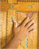  ?? NEW YORK TIMES FILE PHOTO ?? Isabro Ortega touches a door he carved at his home in Truchas. The house, dubbed La Casa de las Nubes, the House of the Clouds, is filled with similar fine details after Ortega worked on it for more than three decades.