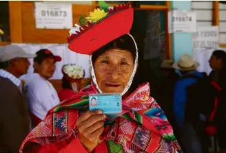  ?? Teo Bizca/AFP ?? Peruana exibe documento em local de votação em Ollantayta­mbo, região de Cuzco