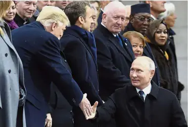  ?? — AFP ?? Reaching out: Putin greeting Trump at a ceremony at the Arc de Triomphe in Paris to mark the 100th anniversar­y of the end of World War I.