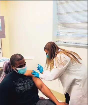  ?? Samuel Diaz/Southwest Community Health Center / Contribute­d photo ?? Carmen Rivera-Torres, chief nursing officer at Southwest Community Health Center in Bridgeport, delivers the first doses of the Moderna COVID-19 vaccine to frontline staff on Wednesday.