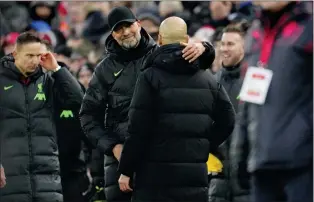  ?? JON SUPER — THE ASSOCIATED PRESS ?? Liverpool’s manager Jurgen Klopp, left, hugs Manchester City’s head coach Pep Guardiola after the English Premier League soccer match at Anfield Stadium on Sunday.