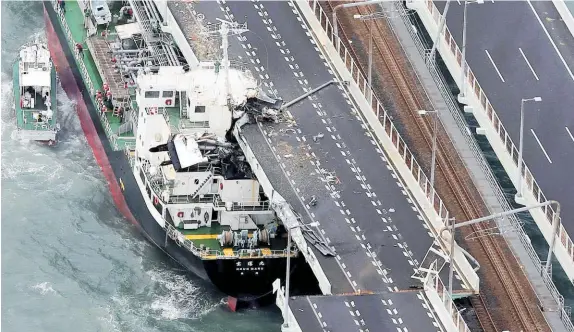 ?? Photos / AP ?? A tanker is pushed into a bridge connecting the airport to the mainland in Osaka.