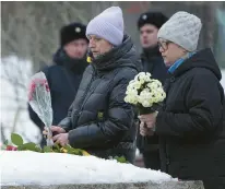  ?? ALEXANDER ZEMLIANICH­ENKO/AP ?? Women pay tribute to Kremlin critic Alexei Navalny on Saturday in Moscow. He died Feb. 16.