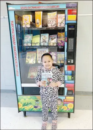  ?? COURTESY PHOTO ?? Student Naomi Franco holds up a book she got from the new book vending machine at Anderson Elementary School. Students are rewarded with trips to the machine for good behavior.