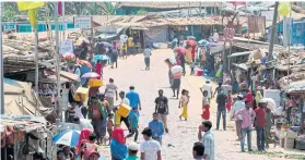  ?? AFP ?? Rohingya refugees, without wearing any mask or any other protective gear as a preventive measure against the Covid-19 novel coronaviru­s, gather along a market area in Kutupalong refugee camp in Ukhia on Tuesday.