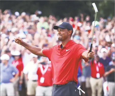  ?? Tim Bradbury / Getty Images ?? Tiger Woods celebrates making a par on the 18th green to win the Tour Championsh­ip at East Lake Golf Club on Sunday in Atlanta.