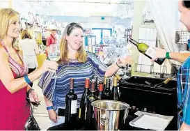  ?? David Hopper ?? The Woodlands residents Shanna Davis and Chantele Sinnett tried a sample of wine from Addison Martin during last year’s H-E-B Wine Walk at Market Street in The Woodlands.