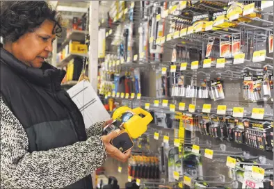  ?? Hearst Connecticu­t Media file photo ?? Marcia Kallon shops for a flashlight and batteries at Keough’s Paint and Hardware in Stamford in 2013.