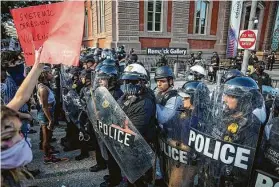  ?? Tasos Katopodis / TNS ?? Police keep protesters back May 30 during a protest in Lafayette Square Park in Washington, D.C. Police killings have set off clashes between protesters and police.