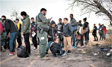 ?? FOTO: AGENCIA AFP ?? Un grupo de migrantes es procesado por la Patrulla Fronteriza después de cruzar el río por un paso no autorizado cerca de la carretera. La Frontera entre México y Estados Unidos en Texas está cerrada.
