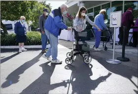  ?? LYNNE SLADKY — THE ASSOCIATED PRESS ?? Robert Owens, 90, stands in line with other residents to receive the Pfizer-BioNTech COVID-19 vaccine at John Knox Village in Pompano Beach, Fla., on Tuesday.