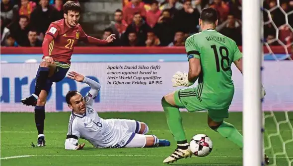  ??  ?? Spain’s David Silva (left) scores against Israel in their World Cup qualifier in Gijon on Friday.