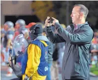  ?? ROBERTO E. ROSALES/JOURNAL ?? ABOVE: UNM Athletic Director Eddie Nuñez takes a quick cellphone photo during a Lobo football game.