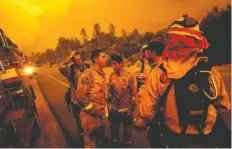  ?? AP PHOTO BY NOAH BERGER ?? Firefighte­rs discuss plans Thursday while battling the Carr Fire in Shasta, Calif. About 37,000 people have evacuated the area.