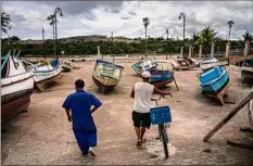  ?? Ramon Espinosa / Associated Press ?? Fishermen in Havana, Cuba, inspect their boats Monday after they were taken out of the bay to avoid storm damage.