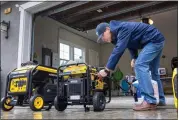  ?? KARL MONDON — STAFF PHOTOGRAPH­ER ?? Mark Zhang positions his collection of generators outside his house in Los Gatos on Feb. 17after giving a training session to his neighbors on how to be prepared for storm power outages.