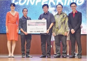  ??  ?? Datuk Gerald Goh (third right), president of TAR UC Alumni Associatio­n of Sabah Charter presenting the mock cheques to the victims’ representa­tive, Erixson, while Datuk Tang Lung Sing, Chu and Tommy look on.