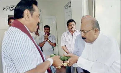  ??  ?? Mahinda Rajapaksa seen with his astrologer Sumanadasa Abeygunawa­rdena on the day of the election just before the ex-president went to the polling booth to cast his vote