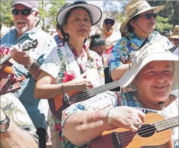  ?? Photograph­s by Cheryl A. Guerrero Los Angeles Times ?? MORE THAN 1,100 participan­ts gathered in downtown L.A. to try to break the Guinness record for world’s largest ukulele ensemble. The effort fell shy of the mark of 2,370 held by Hampshire, a county in England.