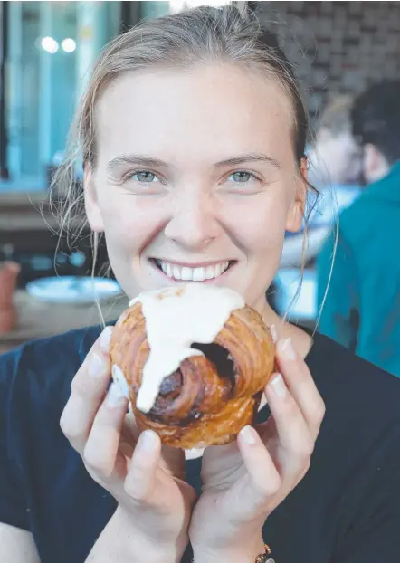  ?? Picture: RICHARD GOSLING ?? Susannah Hunt tries out a Cinnabon Cruffin at Bam Bam Bakehouse, Mermaid Beach.