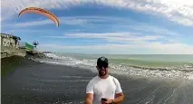  ??  ?? Adam Lawrence films his father Mark flying his motorised paraglider above Haumoana beach.