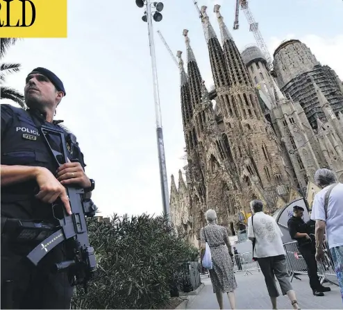  ?? PASCAL GUYOT / AFP / GETTY IMAGES ?? A police officer stands by the Sagrada Familia basilica in Barcelona on Sunday, before a mass to commemorat­e the victims of two devastatin­g terror attacks in Barcelona and Cambrils that killed 14 people last week.