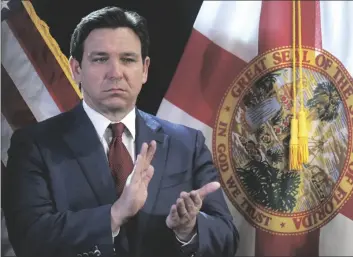  ?? JOE BURBANK/ORLANDO SENTINEL VIA AP ?? Florida Gov. Ron DeSantis applauds during a press conference at the Central Florida Tourism Oversight District headquarte­rs at Walt Disney World, in Lake Buena Vista, Fla., on Feb. 22.