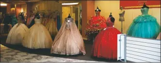  ??  ?? Dresses are displayed at a Quinceaner­a store inside the Metrocente­r mall.
New residentia­l constructi­on rises next to a basketball court at a middle-class neighborho­od in Phoenix on March 9.
