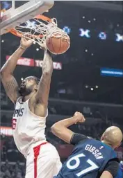  ?? Kyusung Gong Associated Press ?? DeANDRE JORDAN HANGS in there after making a dunk against the Timberwolv­es’ Taj Gibson.