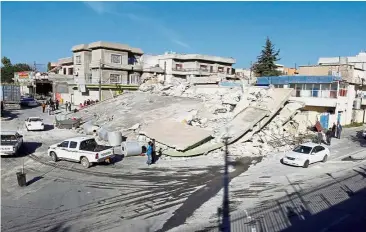  ??  ?? Flattened: A collapsed building in the town of Darbandikh­an. — Reuters