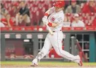  ?? | AP ?? Reds second baseman Scooter Gennett belts a three- run homer during the seventh inning against the Brewers.