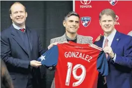  ?? TONY GUTIERREZ/AP ?? FC Dallas President Dan Hunt, left, and Chairman and CEO Clark Hunt, right, present newly hired head coach Luchi Gonzalez with his team jersey during a news conference Monday.