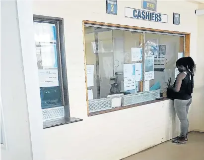  ?? Picture: JOHN HARVEY ?? AT LAST: A woman is helped at the traffic department’s Braelyn offices. For much of the morning on Thursday there was only one cashier on duty, leaving people waiting in queues for hours.