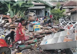  ?? Reuters ?? Children collect snacks from a collapsed shop in South Lampung, Indonesia