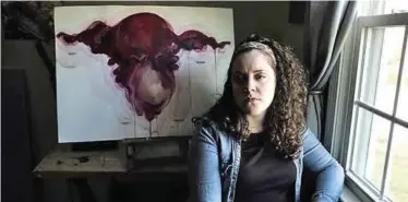  ??  ?? Artist Ashley MacLure sits for a photo with one of her paintings at her home in Milford, Mass. — AP photos