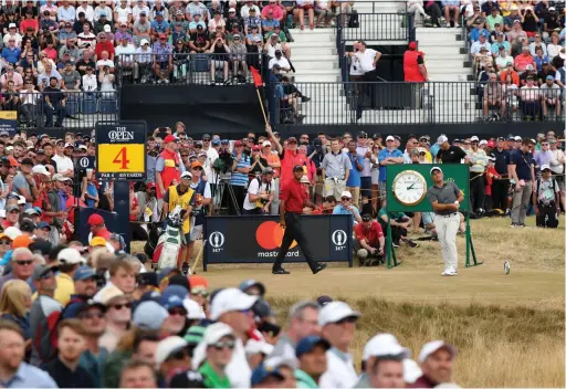  ??  ?? GREAT SHOT, CHAMP: Tiger Woods looks on as Francesco Molinari of Italy plays off the 4th tee during the final round of the Open Golf Championsh­ip in Carnoustie.