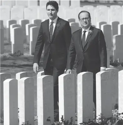  ?? ADRIAN WYLD / THE CANADIAN PRESS ?? Prime Minister Justin Trudeau and French President François Hollande visit the Cabaret-Rouge Commonweal­th war graves cemetery Sunday near Vimy Ridge on the 100th anniversar­y of Canada’s victory there.