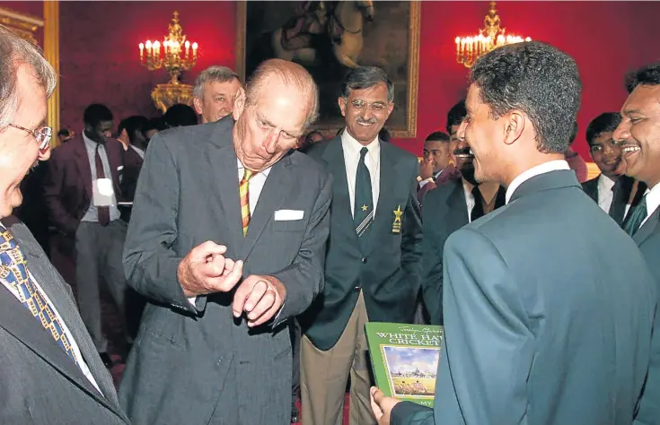  ??  ?? DEMONSTRAT­ING: The duke pulls a face, above, while talking with Pakistan’s captain and wicket keeper Kashif Mahmood during a reception for the under-15 cricket teams at St James’s Palace, London.