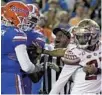  ?? JOHN RAOUX/AP ?? Officials break up an argument between Florida quarterbac­k Kyle Trask (11) and Florida State defensive back Akeem Dent (27) during the 2019 season in Gainesvill­e.