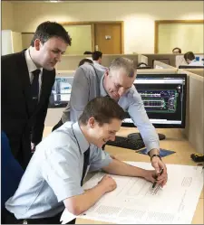  ?? Pat Ryan, Padraig Harty and John Fleming examine some technical plans in the Dairymaste­r Design Department. ??